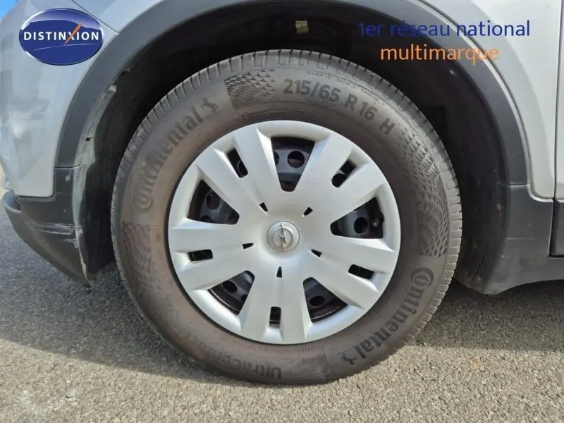 Gros plan sur la roue avant gauche d’un Opel Mokka X gris minéral avec jante en alliage et pneu Continental.
