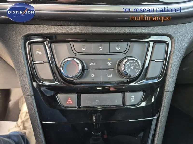 Vue rapprochée de la console centrale noire de l'Opel Mokka X 2018 avec commandes de climatisation et boutons de sécurité.