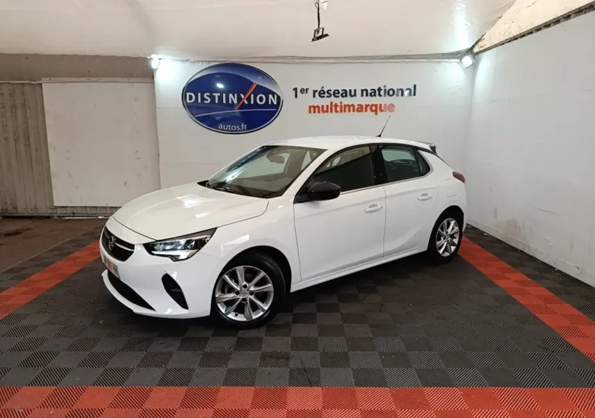 Opel Corsa blanc vue 3/4 avant droit dans un showroom avec jantes alliage et rétroviseurs noirs.