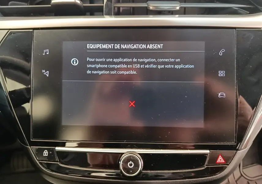 Écran tactile central de la console d’une Opel Corsa blanche, affichant un message d’équipement de navigation absent.