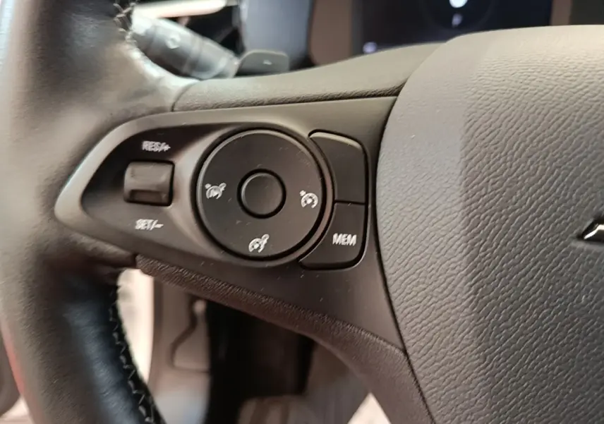 Gros plan sur le volant cuir noir de l’Opel Corsa 2022, avec commandes multifonctions côté gauche visibles.