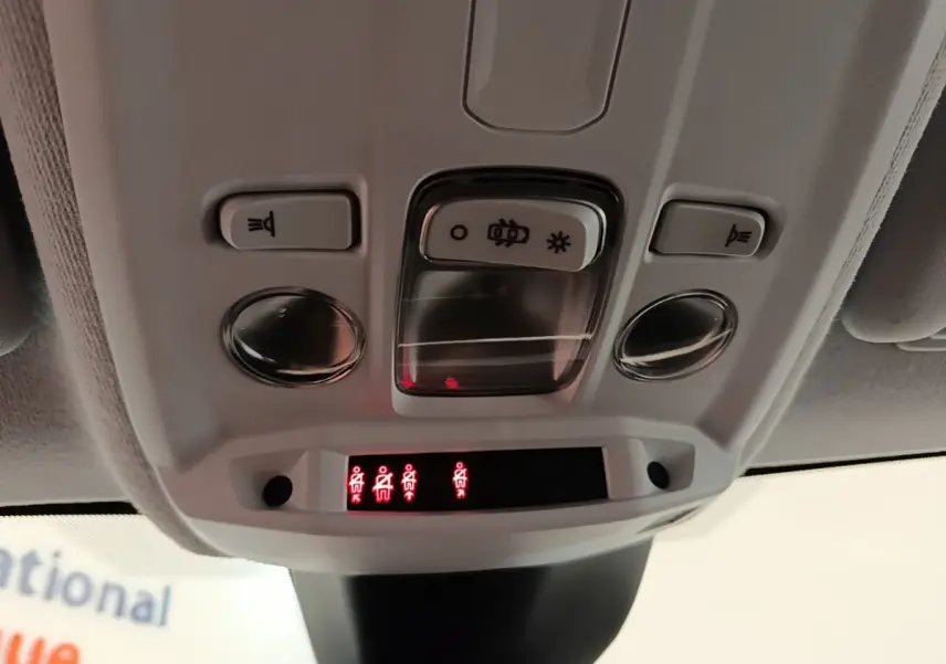 Vue en gros plan du plafonnier intérieur blanc de l’Opel Corsa 2022 avec commandes d’éclairage et indicateurs rouges.