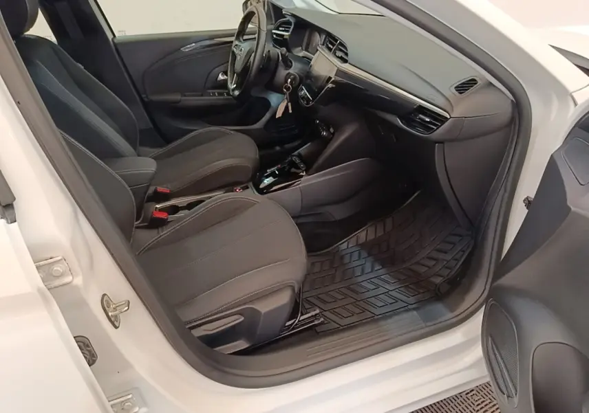 Vue intérieure côté conducteur de l'Opel Corsa blanc 2022, sièges noirs et tableau de bord avec écran tactile.