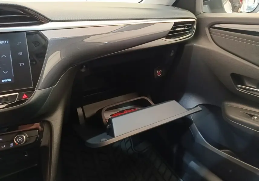 Intérieur de l’Opel Corsa 2022, vue côté passager sur la boîte à gants ouverte et tableau de bord noir.
