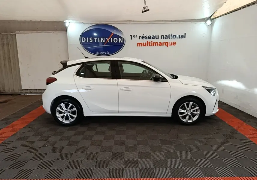Vue latérale droite d'une Opel Corsa blanche 2022 avec jantes alliage et toit noir dans un showroom.