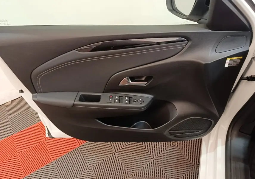 Vue rapprochée de la porte avant gauche blanche d'une Opel Corsa 2022, avec commandes électriques et garniture noire.