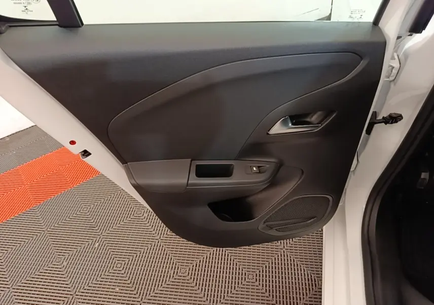 Vue rapprochée de la porte arrière droite blanche d'une Opel Corsa 2022 avec panneau intérieur noir et poignée chromée.