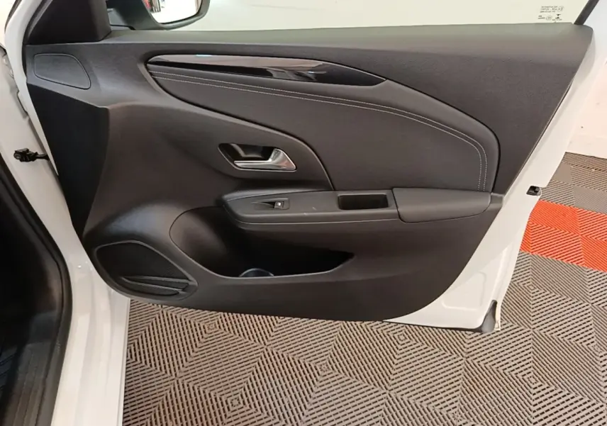 Vue intérieure de la porte avant gauche noire avec surpiqûres blanches d'une Opel Corsa blanche 2022.