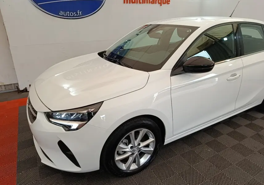 Opel Corsa blanc vue 3/4 avant droit, avec rétroviseurs noirs et jantes alliage argentées.