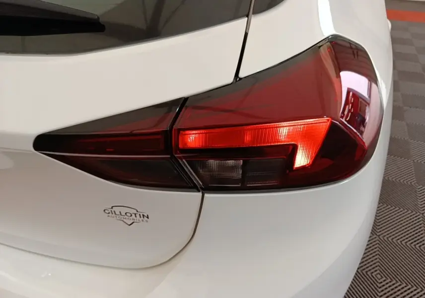 Gros plan sur le feu arrière droit d’une Opel Corsa blanche 2022, avec logo Gillotin visible sur le hayon.