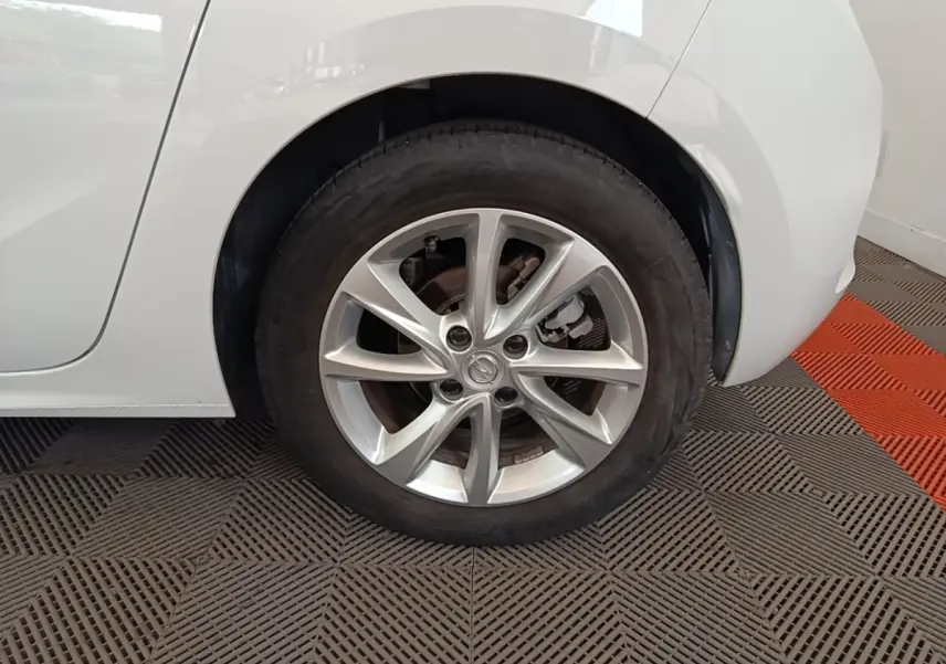 Gros plan sur la roue arrière droite d’une Opel Corsa blanche 2022 avec jante alliage à plusieurs branches.
