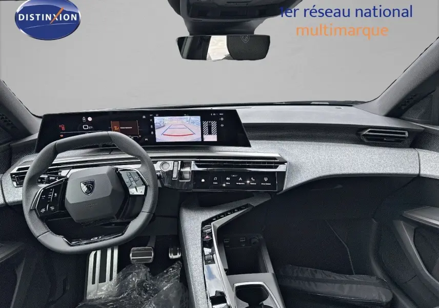 Vue intérieure du tableau de bord et volant du Peugeot 3008 Hybrid 2025 en noir perle métal, avec écran tactile et caméra de recul affichée.