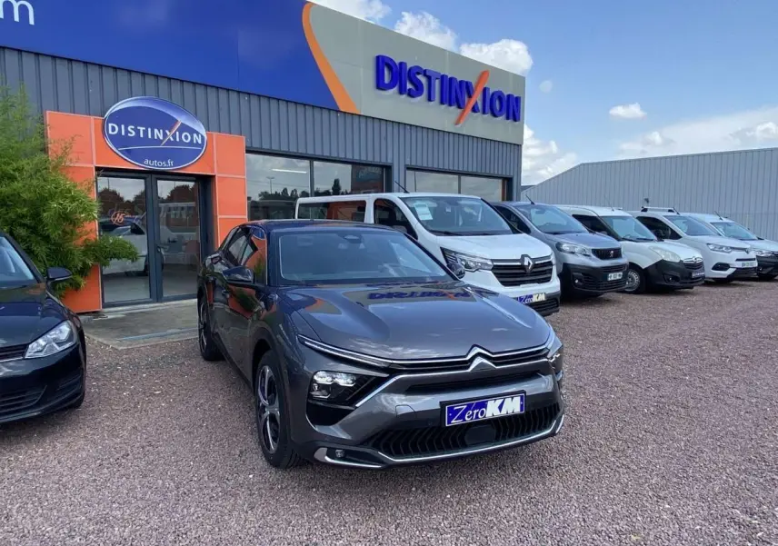 Citroën C5 X gris platinium vue 3/4 avant droit sur parking devant concession Distinxion.