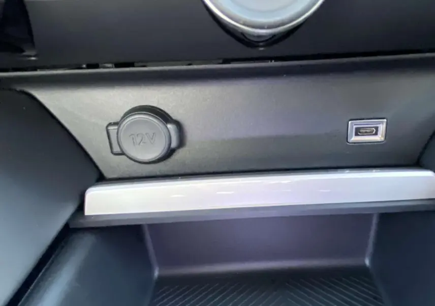Prise 12V et port USB intégrés dans la console centrale noire du Citroën C5 X 2023 finition Feel Pack.