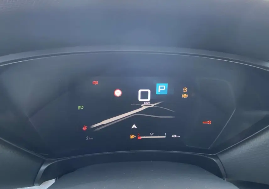 Tableau de bord numérique du Citroën C5 X 2023 affichant la vitesse à 0 km/h et l'indicateur de carburant faible.