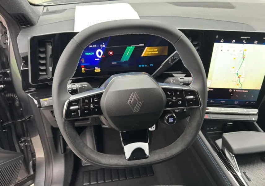 Vue rapprochée du volant et du tableau de bord numérique du Renault Austral ETECH 200 gris schiste avec écran tactile central.