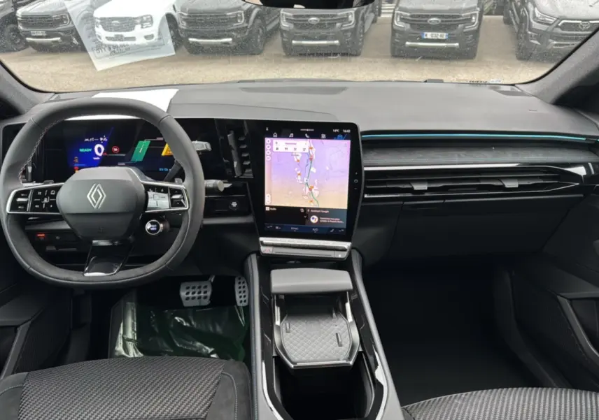 Intérieur du Renault Austral ETECH 200 Esprit Alpine Plus 2025, tableau de bord moderne avec écran tactile vertical et volant multifonction.