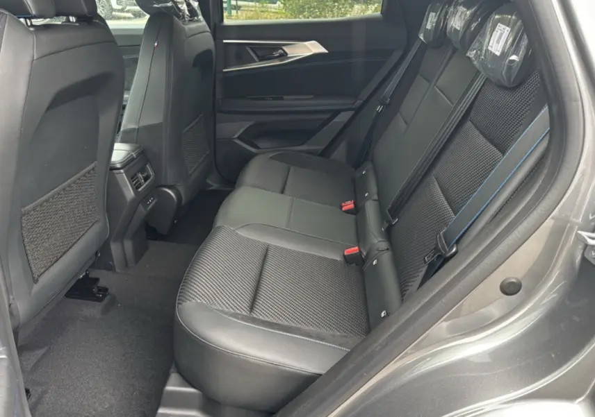 Vue côté droit de l'habitacle arrière du Renault Austral 2025 gris schiste, sièges en cuir et tissu avec surpiqûres bleues.