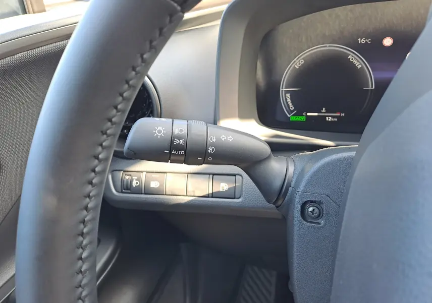 Vue rapprochée du tableau de bord du Toyota C-HR gris minéral 2025, avec bouton Power et commandes au volant visibles.