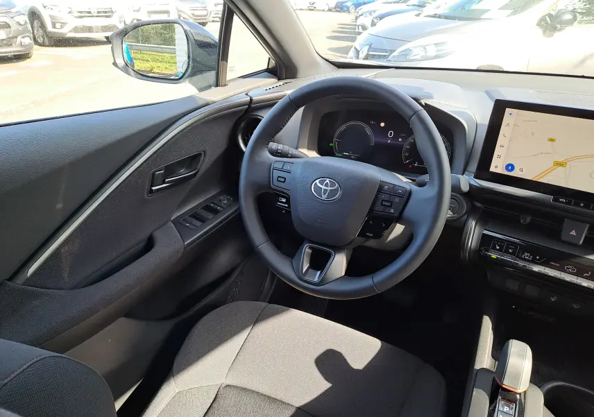 Intérieur côté passager du Toyota C-HR gris minéral 2025 avec écran tactile et aérateurs ronds design.