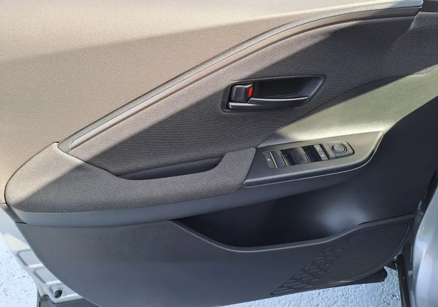 Vue intérieure arrière droite du Toyota C-HR gris minéral 2025, montrant les sièges arrière et le dossier des sièges avant en tissu noir.