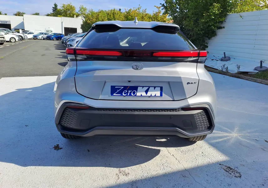 Vue intérieure du tableau de bord du Toyota C-HR gris minéral 2025, avec écran tactile central et volant multifonction.