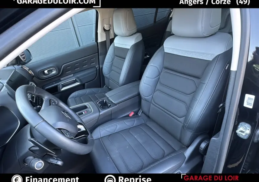 Intérieur du Citroën C5 Aircross noir, vue côté conducteur, sièges cuir noirs avec surpiqûres grises et volant multifonctions.