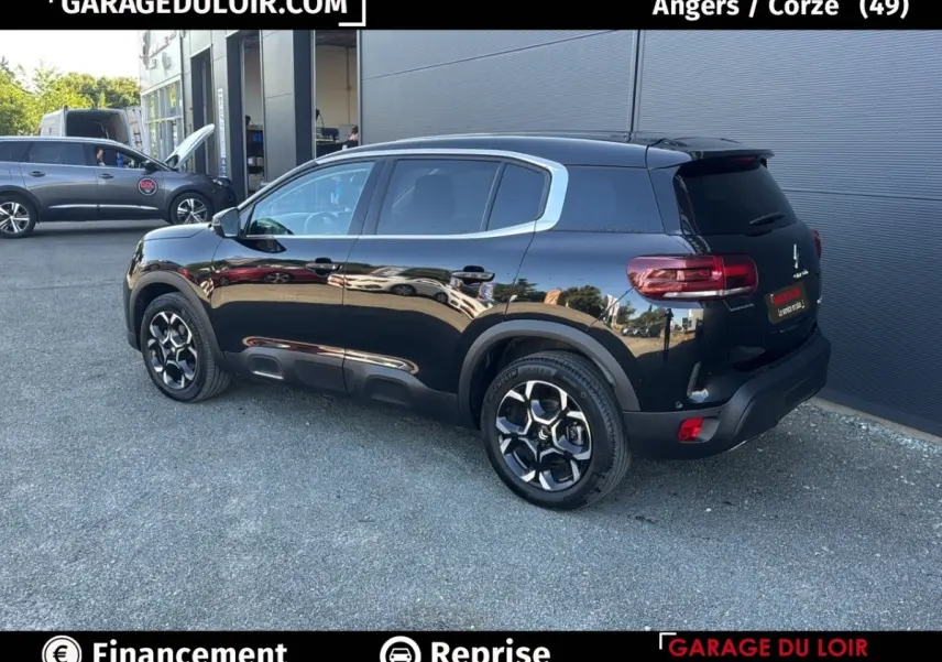Vue 3/4 arrière droite d'un Citroën C5 Aircross noir brillant avec jantes alliage et vitres teintées.