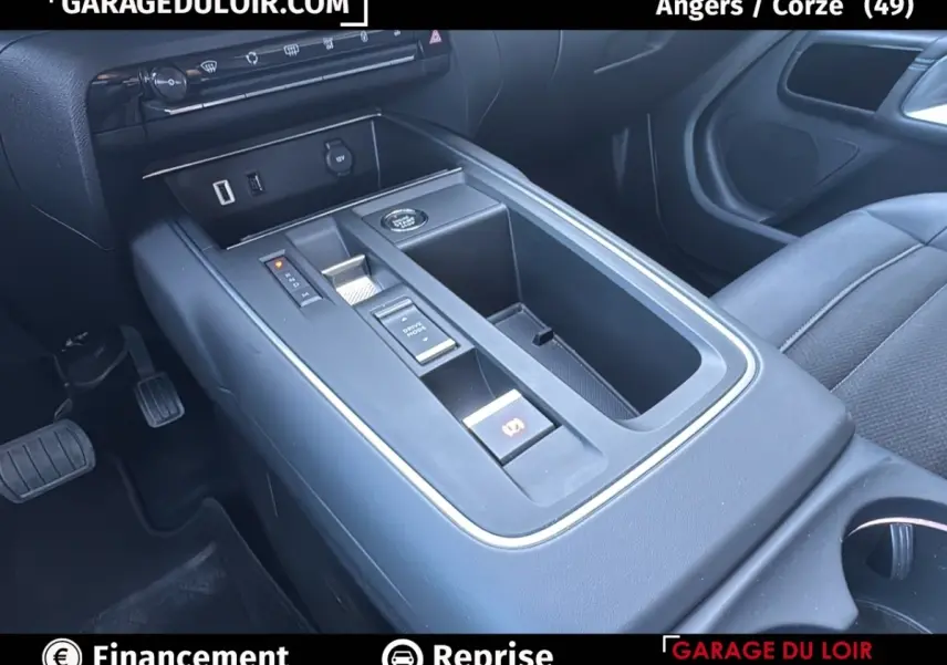 Vue intérieure centrée sur la console centrale noire du Citroën C5 Aircross 2025 avec commandes électroniques et rangements.