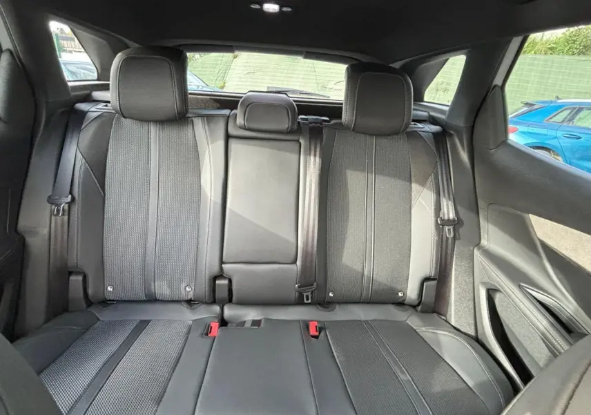Vue arrière intérieure du Peugeot 3008 2024, sièges arrière en sellerie Mi-TEP/tissu noir avec surpiqûres grises.