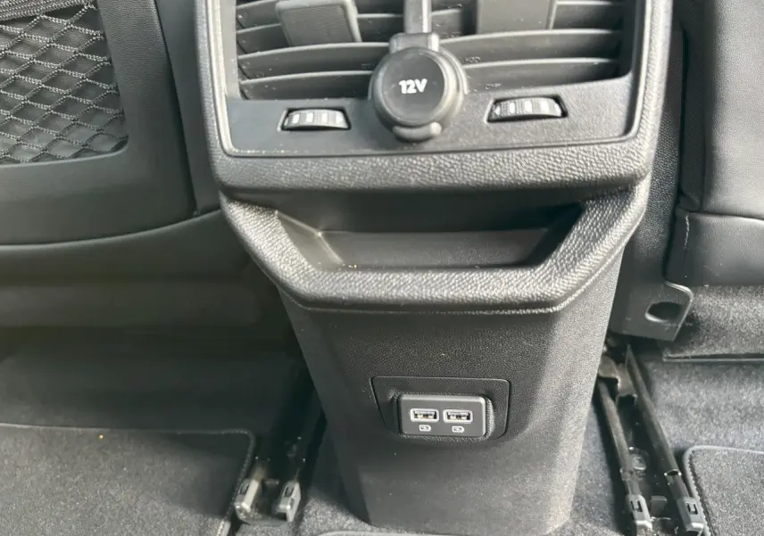 Vue rapprochée de la console arrière noire avec prises USB doubles et prise 12V du Peugeot 3008 GT blanc nacré.