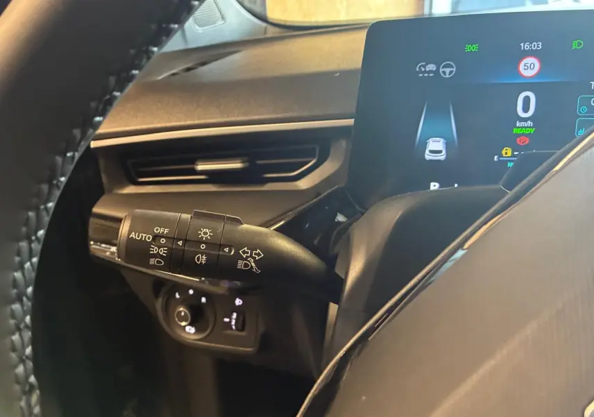 Vue rapprochée du combiné d'instruments et du commodo des phares d'un MG3 1.5 HYBRID+ 195 Luxury noir, intérieur moderne.