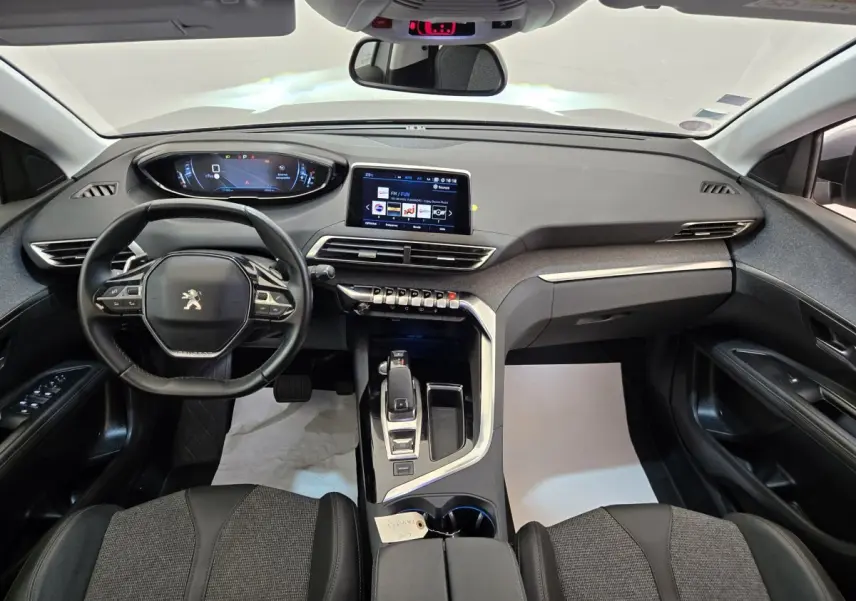 Vue intérieure avant du Peugeot 5008 gris clair, mettant en valeur le tableau de bord digital et l'écran tactile central.