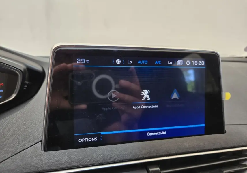 Écran tactile central du Peugeot 5008 affichant les applications connectées, avec tableau de bord noir autour.