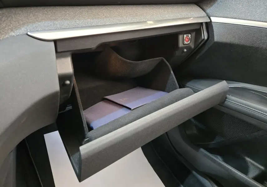Gant de boîte à gants ouvert côté passager dans l’habitacle noir du Peugeot 5008 gris clair, avec livret à l’intérieur.