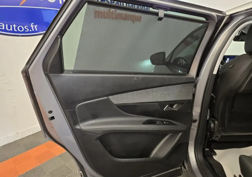 Vue intérieure de la porte arrière droite gris clair du Peugeot 5008 avec store pare-soleil et garniture noire.