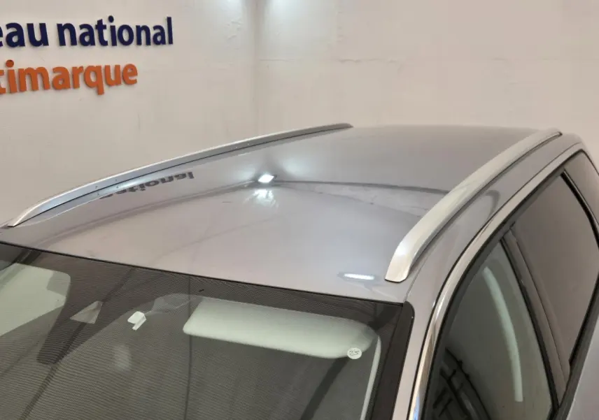 Vue plongeante sur le toit gris clair du Peugeot 5008 avec barres de toit chromées et vitres teintées côté droit.