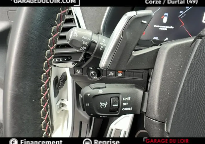 Gros plan sur la commande de régulateur de vitesse et volant cuir avec surpiqûres rouges dans DS7 Crossback blanc 2020.