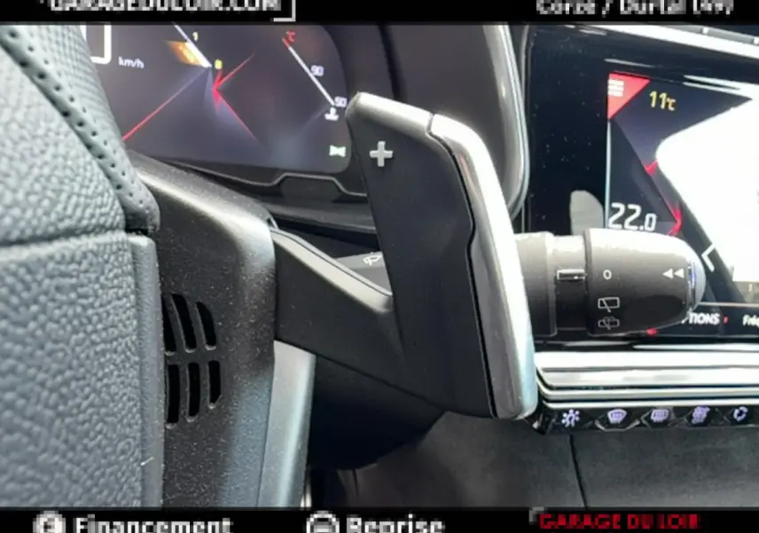 Gros plan sur la palette de changement de vitesse côté droit du volant noir du DS7 Crossback blanc, avec tableau de bord numérique.