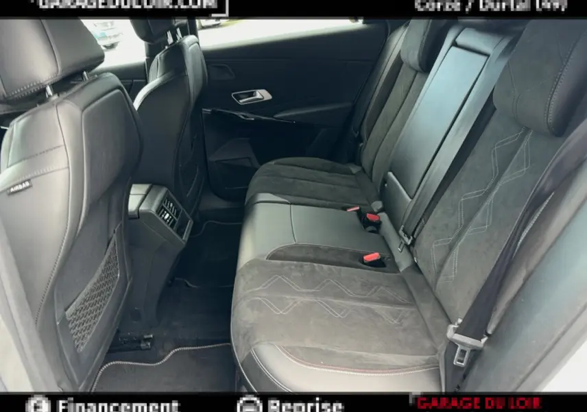 Vue latérale intérieure arrière du DS7 Crossback blanc, montrant les sièges en cuir et alcantara noirs avec surpiqûres décoratives.