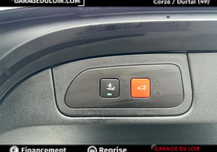 Gros plan sur les boutons de commande du hayon et du verrouillage dans un DS7 Crossback blanc, intérieur noir.