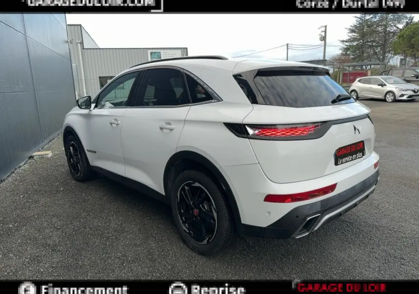 DS7 Crossback blanc vue 3/4 arrière droit, feux arrière LED et jantes noires distinctives visibles.