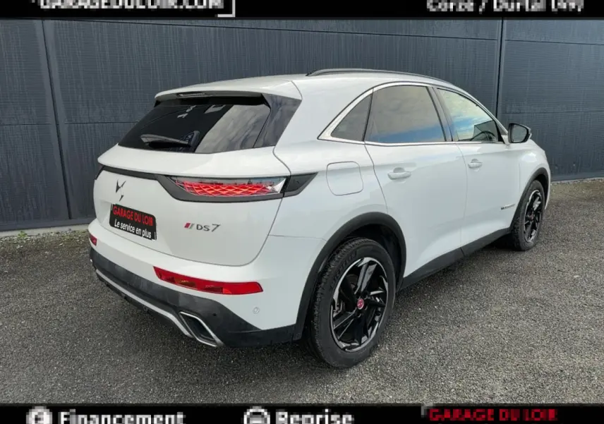 Vue 3/4 arrière droite d'un DS7 Crossback blanc avec jantes noires et feux arrière LED distinctifs.