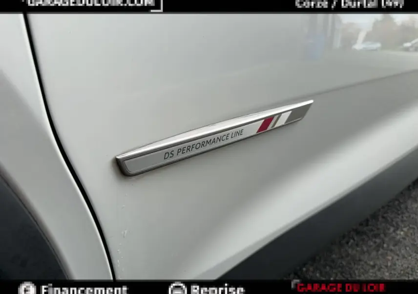 Gros plan sur l’inscription DS Performance Line sur la porte blanche côté gauche d’un DS7 Crossback.