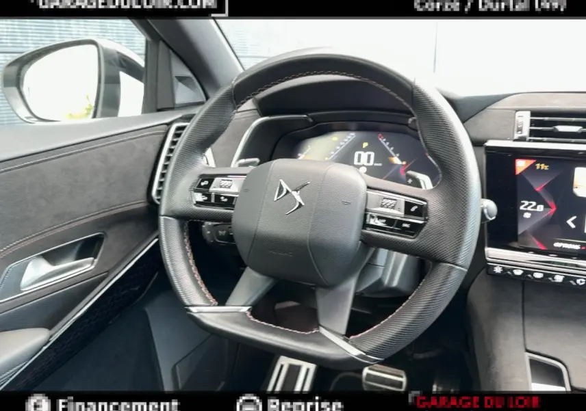 Vue intérieure centrée sur le volant cuir du DS7 Crossback 2020, avec tableau de bord numérique et écran tactile visible.