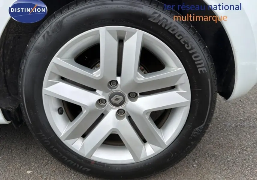 Gros plan sur la roue avant droite d'une Renault Clio blanche, mettant en valeur la jante alliage et le pneu Bridgestone.