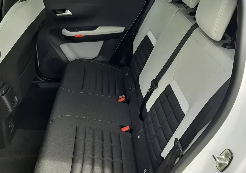 Vue intérieure côté arrière droit du Citroën C3 Aircross blanc banquise, sièges arrière bicolores noir et blanc.