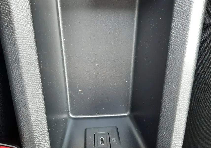 Gros plan sur le compartiment central noir avec port USB-C intégré dans une Citroën C3 Aircross blanc banquise toit noir.