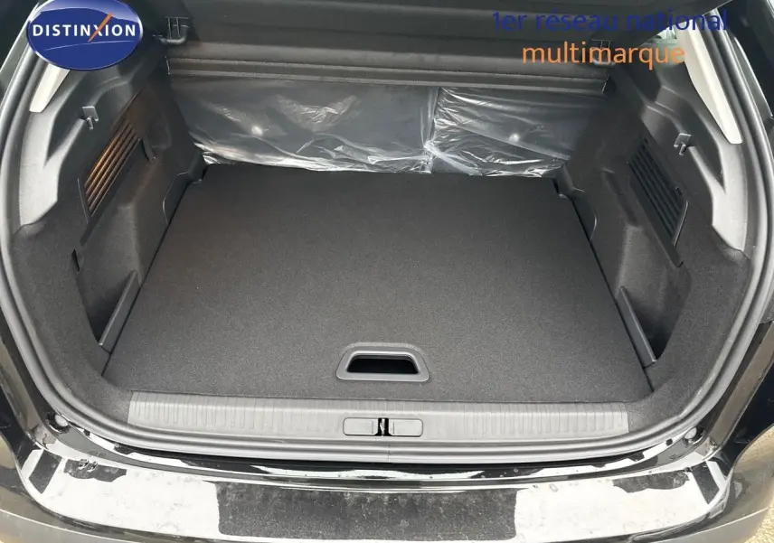Coffre ouvert d'une Citroën C4 noire métal 2024, montrant un espace de chargement propre et spacieux.