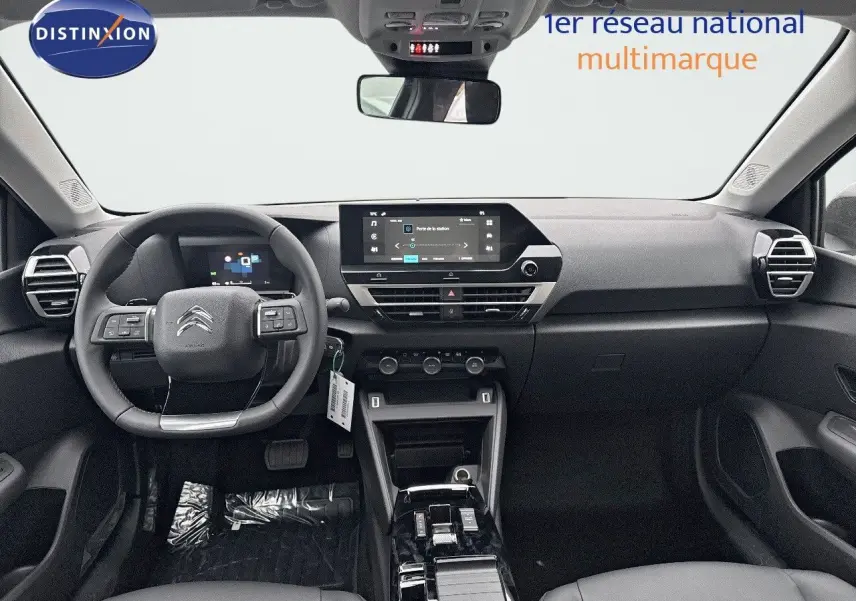 Vue intérieure avant du tableau de bord et volant noir de la Citroën C4 2024 avec écran tactile central et commandes au volant.